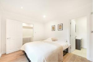 a white bedroom with a white bed in it at Portobello 2-Bed Apartment in London