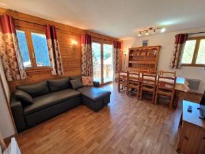 Una sala de estar con un sofá y un comedor. en Appartement Modane 4 pièces, idéal ski, 6-8 pers, 65m², proche télécabine et commerces - FR-1-265-66, en Valfréjus