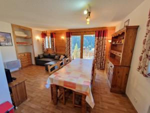 una sala de estar con una mesa y un sofá en Appartement Modane 4 pièces, idéal ski, 6-8 pers, 65m², proche télécabine et commerces - FR-1-265-66, en Valfréjus