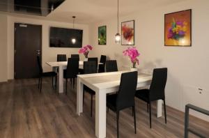 a dining room with a white table and black chairs at Hostel Old Town in Bratislava +7 photos