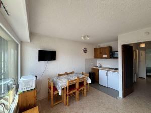 a kitchen and dining room with a table with chairs and a kitchen at Appartement 6 couchages au pied des pistes avec balcon - Auris en Oisans - FR-1-297-108 in Auris