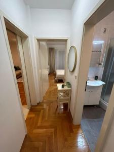 een hal van een badkamer met een wastafel en een spiegel bij Apartmani Adele in Srima