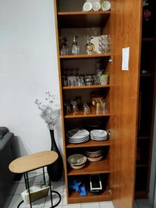 a wooden book shelf with dishes and a stool at Maison agréable à Le Crotoy, 57 m² avec vélos inclus in Le Crotoy