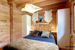 a bedroom with a bed in a wooden wall at Chalet de Cécile 1 in Besse-et-Saint-Anastaise +10 photos