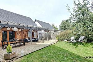a backyard with a wooden deck with a table and chairs at Chalet de Cécile 1 in Besse-et-Saint-Anastaise