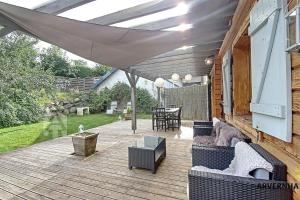 a patio with couches and a table on a deck at Chalet de Cécile 1 in Besse-et-Saint-Anastaise