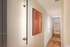 a hallway with a door with a painting on the wall at B&B HOTEL Apartamentos Madrid Centro Fuencarral 46 in Madrid