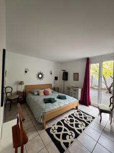 ein Schlafzimmer mit einem Bett und einem Tisch und Stühlen in der Unterkunft la vue des étangs in Bages