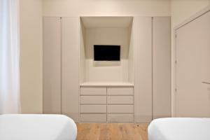 a bedroom with a tv and a white wall at B&B HOTEL Apartamentos Madrid Centro Fuencarral 46 in Madrid