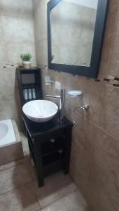 un baño con lavabo y espejo en Monchos House, en Merlo