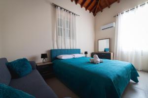 1 dormitorio con 1 cama azul y 1 sofá en Elite Luxury Suites Omodos, en Omodos