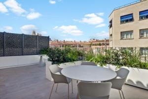 a patio with a white table and chairs on a balcony at B&B HOTEL Apartamentos Madrid Centro Fuencarral 46 in Madrid