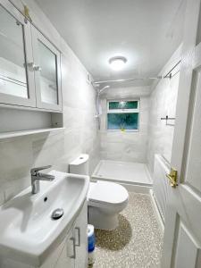 ein weißes Badezimmer mit Toilette und Waschbecken in der Unterkunft Stylish cottage in vibrant riverside village in North Ferriby