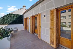 a balcony with wooden doors and a table on a building at B&B HOTEL Apartamentos Madrid Centro Fuencarral 46 in Madrid