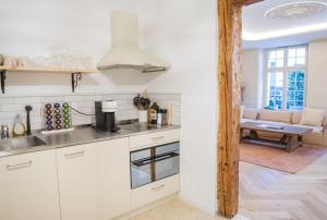 a kitchen with white cabinets and a living room at Exklusive Stadtwohnung mit Innenhofterrasse, Pool und Sauna in Bern