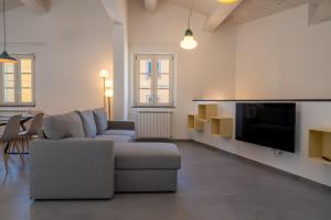a living room with a couch and a flat screen tv at La casa dei Sentieri in San Giuliano Terme