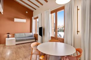 a living room with a table and chairs and a couch at B&B HOTEL Apartamentos Madrid Centro Fuencarral 46 in Madrid