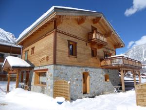 a log cabin in the snow with a balcony at Chalet Haut de Gamme 5P avec Mezzanine, Parking, Proche Téléphérique et Pistes - Pralognan-la-Vanoise - FR-1-464-7 in Pralognan-la-Vanoise