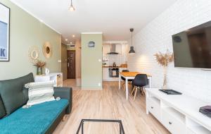 a living room with a couch and a tv at Dwa pokoje w centrum - darmowy parking in Świnoujście