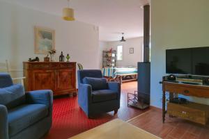 a living room with blue chairs and a flat screen tv at maison au calme la chaume 6 personnes in La Chaume