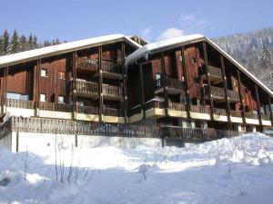 budynek z śniegiem na ziemi przed nim w obiekcie Appartement cosy 5 pers., pied des pistes, balcon est, proche commerces, parking & services - FR-1-572-94 w mieście Arâches-la-Frasse