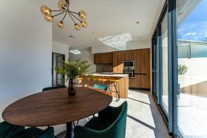 a kitchen and dining room with a wooden table and chairs at Maison élégante avec piscine in Tournon-sur-Rhône
