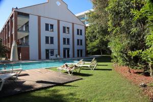 Lagos, Meia Praia Beach, Marina Apartment في لاغوس: مسبح وكراسي صالة ومبنى