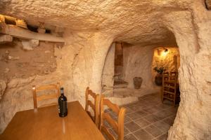 a wine bottle sitting on a table in a stone room at Casa Rural Gandia in Bocairent