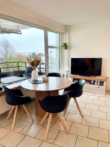 Un comedor con mesa y sillas y un televisor. en Prinzenhof "Lieblingsplatz" App 27 inkl WLAN, en Grömitz