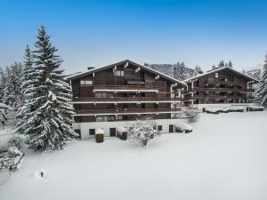 a large building in the snow with snow covered trees at Appartement 3 pièces avec balcon, cheminée et parking – À 400m des pistes et du golf, Megève Mont d'Arbois - FR-1-453-254 in Megève