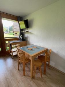 a dining room with a table and chairs and a desk at Le repère du Nant- meublé classé 2 étoiles in Morzine +2 photos