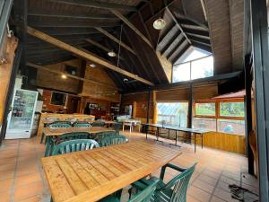 a dining room with wooden tables and green chairs at Portal del Manzano in Villa La Angostura