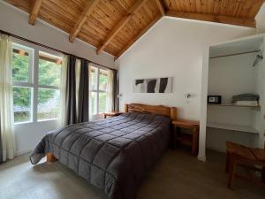 a bedroom with a bed in a room with windows at Portal del Manzano in Villa La Angostura +102 photos