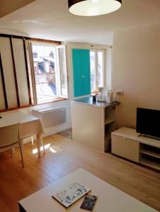 a living room with a kitchen with a table and a counter at Suit Mary in Rennes