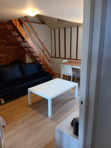 a living room with a white table and a couch at Suit Mary in Rennes