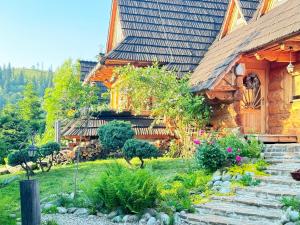 a house with a garden in front of it at GORSKA OSADA Lovely Chalets Zakopane in Poronin +101 photos