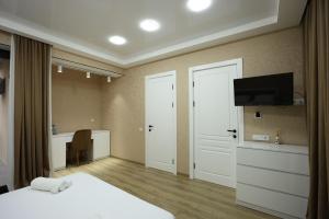 a bedroom with a bed and a desk and a television at Chanko Hotel in Borjomi