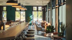 汉堡Holiday Inn - the niu, Bricks Hamburg Eppendorf by IHG的带酒吧的餐厅，酒吧里有椅子和桌子