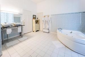 ein weißes Badezimmer mit zwei Waschbecken und einer Badewanne in der Unterkunft Hotel Joly in Armentières + 61 Fotos