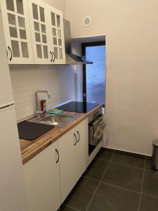 a kitchen with white cabinets and a sink at M&O Belgrade in Belgrade +8 photos