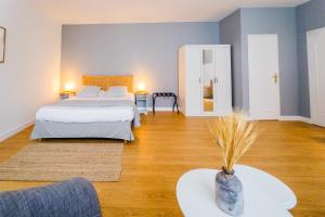 ein Zimmer mit zwei Betten und einem Tisch mit einer Vase in der Unterkunft Hotel Joly in Armentières