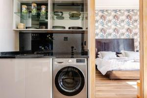 a kitchen with a washing machine next to a bed at Modern Ocean View Apartment - Pestana Anfa Place in Casablanca