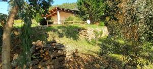 a house on a hill with a pile of logs at Casa in Maremma in Montemerano