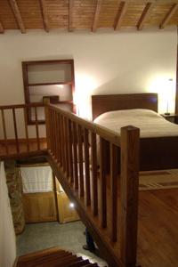 a bedroom with a bed and a wooden staircase at Casa da Fonte de Travanca in Travanca