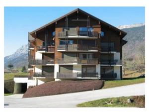 ein großes Gebäude mit Balkonen an der Seite in der Unterkunft Duplex ensoleillé et calme, proche des pistes - Parking et casier à skis inclus - FR-1-459-187 in Saint-Jean-de-Sixt