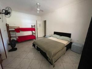 a bedroom with a large bed and a fan at Hostel da Penha in Vila Velha