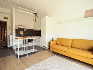 a living room with a couch and a kitchen at Kasprzaka Apartment parking in Łódź
