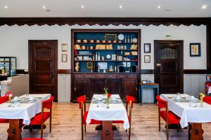 ein Esszimmer mit zwei Tischen und roten Stühlen in der Unterkunft Hotel Joly in Armentières