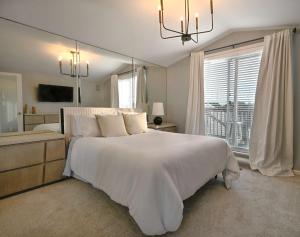 バージニアビーチにあるModern 4bdr Oceanfront homeの大きな白いベッドと窓のある寝室