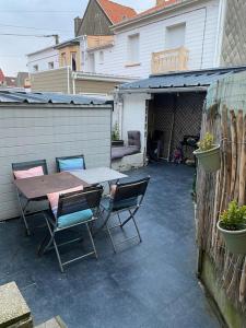 a patio with a table and chairs in a backyard at La clairière Merlimont in Merlimont